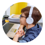 a boy wearing headphones and using a laptop